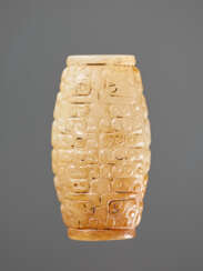 A SUPERB BARREL-SHAPED BEAD IN WHITE JADE WITH MASK MOTIFS AND CURLS IN RELIEF