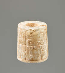 AN INTERESTING THICK EARRING OF THE JUE TYPE IN PARTLY CALCIFIED WHITE JADE DECORATED WITH STYLIZED DRAGON HEADS