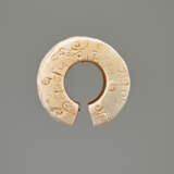 AN INTERESTING THICK EARRING OF THE JUE TYPE IN PARTLY CALCIFIED WHITE JADE DECORATED WITH STYLIZED DRAGON HEADS - фото 4