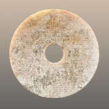 AN INTERESTING PARTLY CALCIFIED BI DISC WITH A GLASSY POLISH AND AN INCISED PATTERN OF LINKED SCROLLS - Foto 1