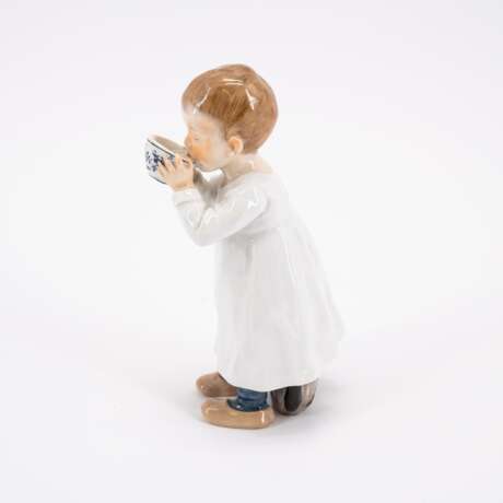 PORCELAIN FIGURINE OF A BOY DRINKING FROM AN ONION PATTERN CUP - Foto 2