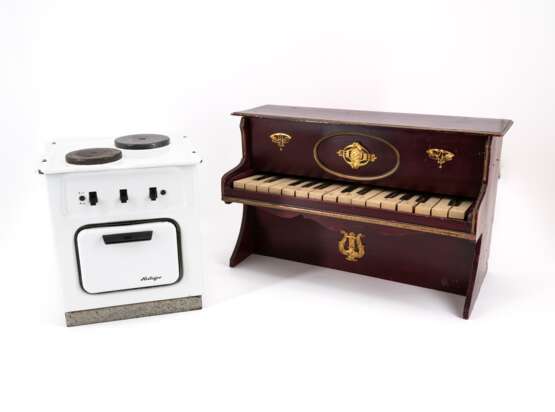 TOY PIANO MADE OF WOOD, BRASS AND PLASTIC AND A DOLL'S COOKING STOVE MADE OF SHEET METAL WITH ENAMEL DECOR - photo 1