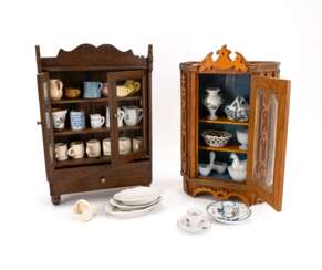TWO MINIATURE CUPBOARDS WITH ALL KINDS OF TABLEWARE MADE OF WOOD, GLASS, METAL, RED CERAMIC AND PORCELAIN