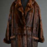Gepflegter Naturnerz Mantel in gerader Form mit Reverskragen, seitlichen Schlitzen, aufgesetzten Taschen und Bindegürtel, ganze Felle, Gr. L, um 2000/2002 - photo 1