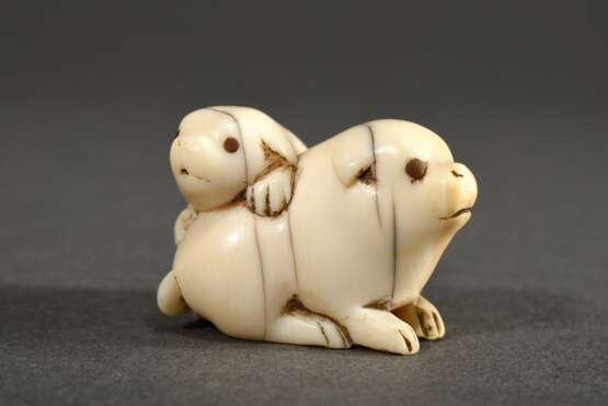 Elfenbein Netsuke "Zwei Welpen" mit eingelegten Horn Augen (1 fehlt), Japan um 1900, H. 2cm, Risse, schöne Alterspatina, Genehmigung nach Art.10d VO (EG 338/97) liegt vor, kein Export außerhalb der EU - фото 1