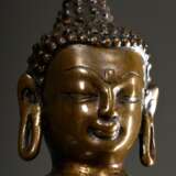 Buddha Shakyamuni auf einem Lotosthron sitzend, seine rechte Hand in der Geste der Erdanrufung, die linke in der Geste der Meditation, der Saum des Mönchsgewandes mit Kupfer eingelegt, Bronze, West-Tibet im Stil des 14./15. Jh., Sockelplatte wieder … - photo 4