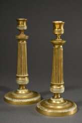 Paar feuervergoldete Bronze Leuchter auf rundem Fuß mit kannelierten Schäften und ornamentalen Friesen, Frankreich 19.Jh., H. 24,5cm, Druckstellen