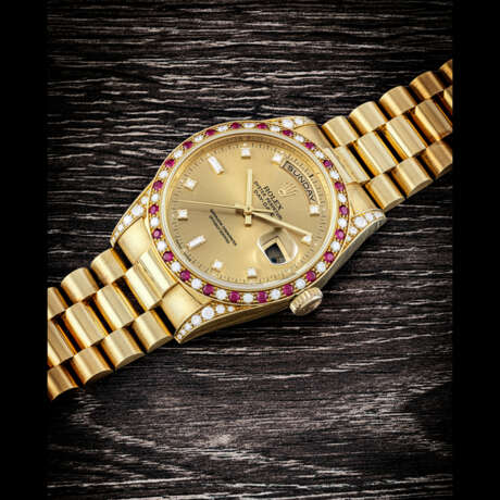 ROLEX. AN 18K GOLD, DIAMOND AND RUBY-SET AUTOMATIC WRISTWATCH WITH SWEEP CENTRE SECONDS, DAY, DATE AND BRACELET - Foto 1