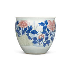A CARVED UNDERGLAZE-BLUE, COPPER-RED AND CELADON-GLAZED ‘MAGNOLIA AND PEONY’ JARDINI&#200;RE