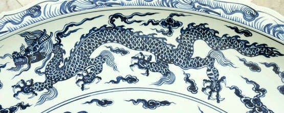 Extraordinary and particular large Chinese blue and white porcelain bowl with round shaped border, waved extended high border rim, decorated with a blue painted dragon in the centre with clouds and four dragons on the sides - photo 3