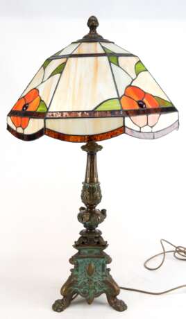 Tischlampe im Tiffanystil, 2. Hälfte 20. Jh., 2-flammig, dreipassiger Bronzefuß auf Klauenfüßen stak reliefiert, 8-kantiger Schirm aus beigem Kunstglas mit buntem Blumendekor, H. 85 cm, Dm. 47 cm - фото 1