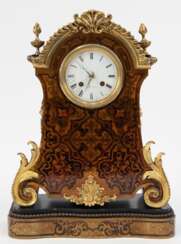 Boulle-Uhr auf Sockel, 19. Jh., bez. &quot;Foy á Paris&quot;, geschwungene Front des Sockel und Front der Uhr mit Messingblech mit ornamentalen und floralen Einlagen, ebonisiertes Holzgehäuse, mit Messing-Appliken und -Perlkante, emailliertes Ziffe…