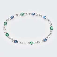 Juwelier Wilm. Außergewöhnliches Schmuckstück mit Smaragden, Saphiren, Blautopasen und Turmalinen.