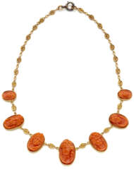 Orange carved coral cameo and yellow gold graduate…