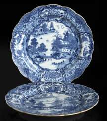 Teller mit passig gewölbter Wandung, unterglasurblauer Dekor einer Gartenszene mit Dame und Dienerin mit Qin, dazu zwei blütenförmige Teller mit unterglasurblauem Dekor
