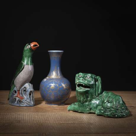 Kleine puderblau glasierte Flaschenvase mit Drachendekor in Gold und zwei grün glasierte Porzellan-Skulpturen von Papagei auf Felsen und liegendem Löwen - фото 1