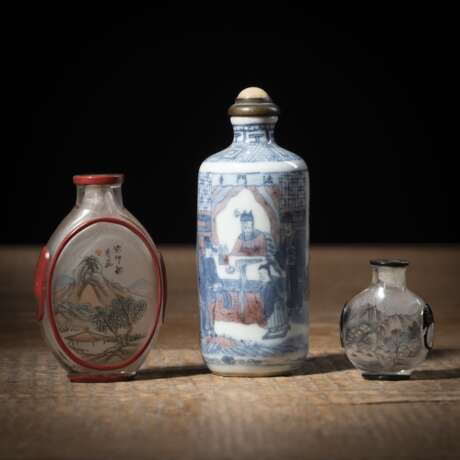 Zylindrische Snuffbottle aus Porzellan mit Theaterszene 'Famen Tempel' in Unterglasurblau und Kupferrot und zwei flache Snuffbottles aus Glas mit Innenmalerei und Überfang - фото 1