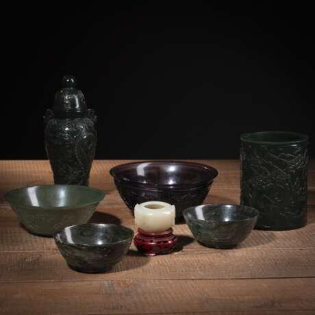 Gruppe von sechs Objekten aus Jade, teils aus Spinatjade: Deckelvase, Pinselbecher, drei Schalen und kleiner Pinselwascher. Dazu eine auberginefarbene Glasschale mit Reliefdekor - photo 1