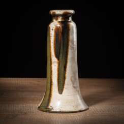 Trompetenförmige Vase aus Steinzeug partiell mit grünlichbraunem Glasurverlauf auf beigem Grund