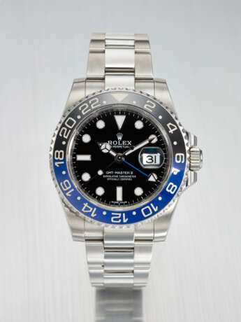 ROLEX. A STAINLESS STEEL DUAL TIME WRISTWATCH WITH SWEEP CENTRE SECONDS, DATE AND BRACELET - Foto 1