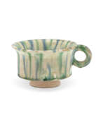 Dynastie Tang. A RARE BLUE, GREEN, AND CREAM-GLAZED POTTERY HANDLED CUP