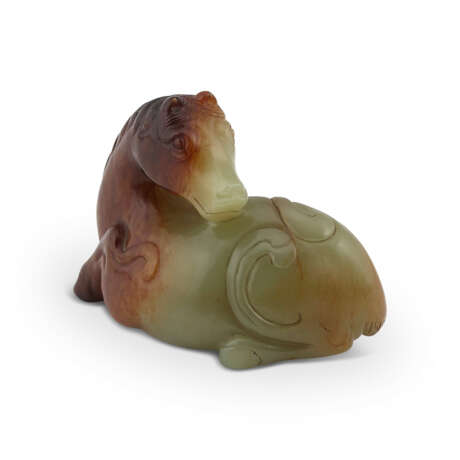 A CELADON AND RUSSET JADE CARVING OF A RECUMBENT HORSE - Foto 1