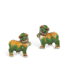 A PAIR OF GREEN, YELLOW AND AUBERGINE-GLAZED BISCUIT BUDDHIST LIONS