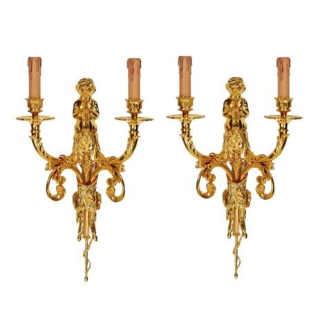 Une paire d`appliques dorees &agrave; volutes de monnaie surmontees d`angelots. Vergoldete Bronze 54 - Foto 1