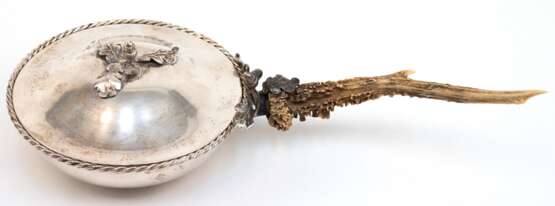 Deckelschale mit Jagdbezug, 800er Silber, um 1900, runde Schale mit Kordelrand und plastischem Eichenlaubdekor, seitlich Rehbockstange als Handhabe, ges. 442 g, Schalen-H. 8 cm, Dm. 15 cm, Ges.-L. 32,5 cm - фото 1
