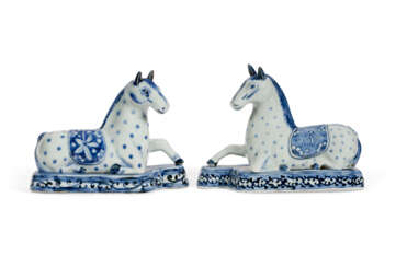 A PAIR OF JAPANESE EXPORT ARITA PORCELAIN BLUE AND WHITE RECUMBENT HORSES