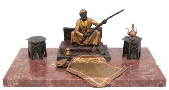 Bronze-Figurengruppe "Sitzender Araber mit Waffe und Interieur", Wiener Bronze, polychrom gefaßt, signiert Bergmann "B in Amphore", beidseitige Hocker aufklappbar, auf rot marmorierte… - Foto 1