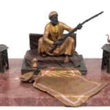 Bronze-Figurengruppe "Sitzender Araber mit Waffe und Interieur", Wiener Bronze, polychrom gefaßt, signiert Bergmann "B in Amphore", beidseitige Hocker aufklappbar, auf rot marmorierte… - photo 1