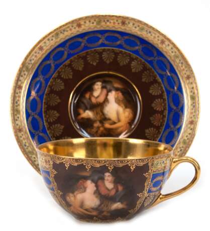 Tasse mit UT, Friedrich Simon, Karlsbad, Tschechoslowakei, um 1920, jeweils mit figürlicher Szene und goldenen Zierkanten auf braunem und blauem Grund, innen vergoldet, Marken: Bienenstockzeichen von Royal Vienna, einer Flagge mit den Worten FSC, Ca… - Foto 1