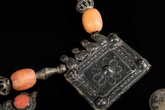 2 Diverse Teile afghanische Ketten: 1 mit 2 eckigen Amulettbehältern und halbrunder Platte sowie farbigen Perlen (L. 25cm) und 1 mit Münzen und verglastem Rauten Medaillon (L. 26cm), Altersspuren (AF61/62) - фото 5