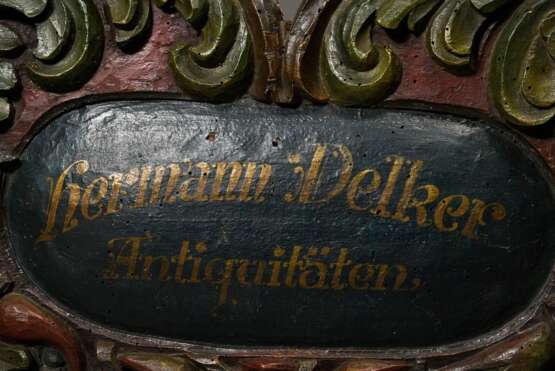 Barocke Schnitzerei Kartusche mit zwei plastischen Engelsköpfen, 18.Jh., später als Ladenschild übermalt "Hermann Delker Antiquitäten", 28x61cm, alter Wurmbefall, leichte Defekte - Foto 2
