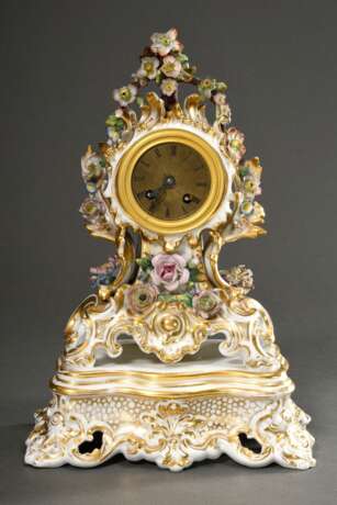 Biedermeier Porzellan Pendule mit reich ornamentiertem und floral dekoriertem Gehäuse auf Rocaille Sockel, polychrom staffiert, guillochiertes Messing Zifferblatt mit geschwärzten römischen Zahlen im Bronze Ring, Schlagw… - фото 1