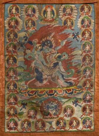 Thangka „Dharmapāla Mahākāla (?) vor Flammenaureole (blaue Körperfarbe und drei Augen) mit hellblauer Paretra mit Schädelschale und Hackmesser in yab-yum, darüber Buddha Amitāyus in Regenbogen, darunter weiterer Dharmapā… - Foto 5