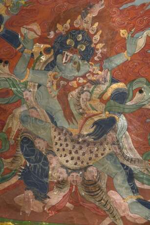 Thangka „Dharmapāla Mahākāla (?) vor Flammenaureole (blaue Körperfarbe und drei Augen) mit hellblauer Paretra mit Schädelschale und Hackmesser in yab-yum, darüber Buddha Amitāyus in Regenbogen, darunter weiterer Dharmapā… - photo 7