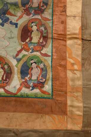 Thangka „Dharmapāla Mahākāla (?) vor Flammenaureole (blaue Körperfarbe und drei Augen) mit hellblauer Paretra mit Schädelschale und Hackmesser in yab-yum, darüber Buddha Amitāyus in Regenbogen, darunter weiterer Dharmapā… - photo 9