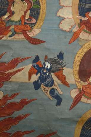 Thangka „Dharmapāla Mahākāla (?) vor Flammenaureole (blaue Körperfarbe und drei Augen) mit hellblauer Paretra mit Schädelschale und Hackmesser in yab-yum, darüber Buddha Amitāyus in Regenbogen, darunter weiterer Dharmapā… - photo 10