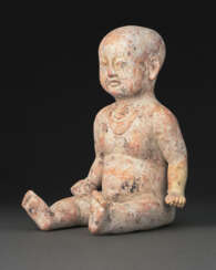 A VERY RARE PAINTED POTTERY FIGURE OF A SEATED BOY