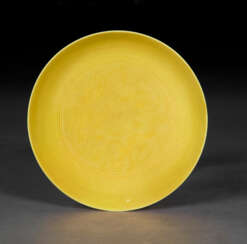 A SMALL INCISED YELLOW-GLAZED &#39;DRAGON AND PHOENIX&#39; DISH