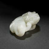 A FINELY CARVED WHITE JADE FIGURE OF A RECUMBENT BEAST - фото 1