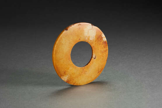 A MOTTLED RUSSET AND PALE-GREENISH-BUFF JADE DISC - Foto 1