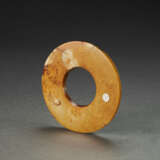 A MOTTLED RUSSET AND PALE-GREENISH-BUFF JADE DISC - Foto 2