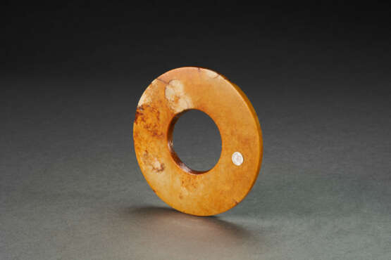 A MOTTLED RUSSET AND PALE-GREENISH-BUFF JADE DISC - Foto 2