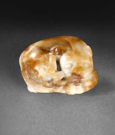 A WELL-CARVED WHITE AND BROWN JADE FIGURE OF A RECUMBENT MYTHICAL BEAST - фото 1