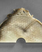 Han dynasty. A RARE PALE GREENISH-WHITE AND BROWN JADE SECTION OF A BI