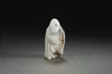 A RARE WHITE AND BLACK JADE FIGURE OF A FOREIGN TRIBUTE BEARER