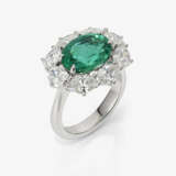 An entourage ring with an emerald and diamonds. - фото 1